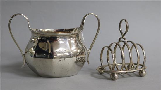A silver sugar bowl and a silver toastrack.